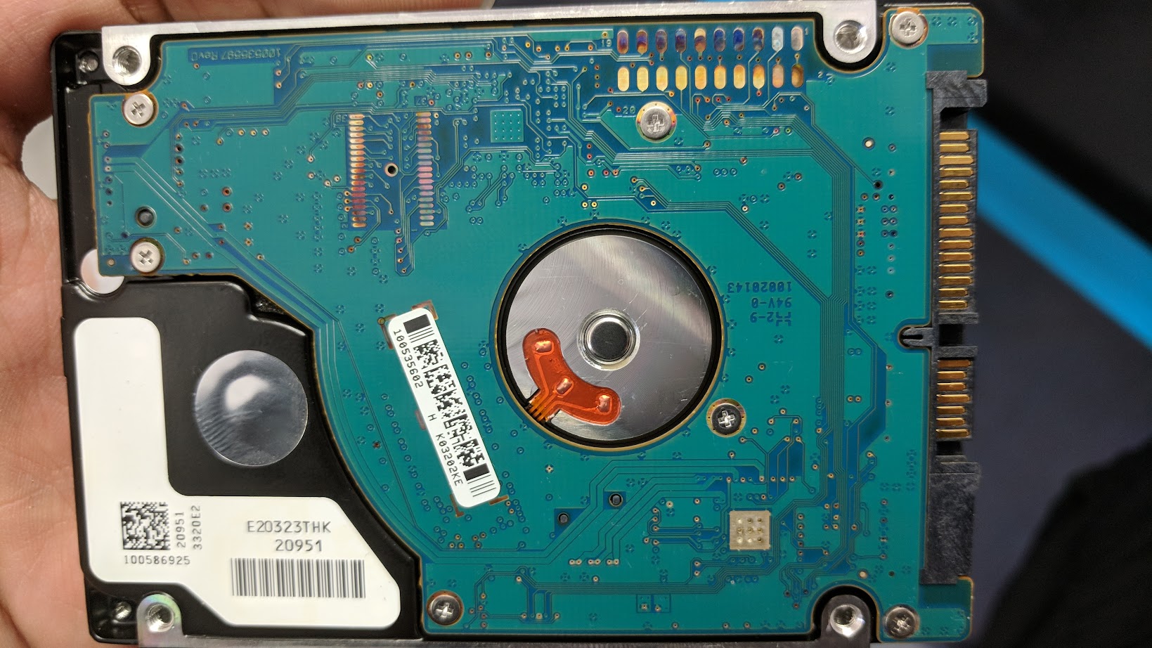 The controller-board side of a laptop hard drive, with severe discoloration from the controller chip overheating and "cooking" itself